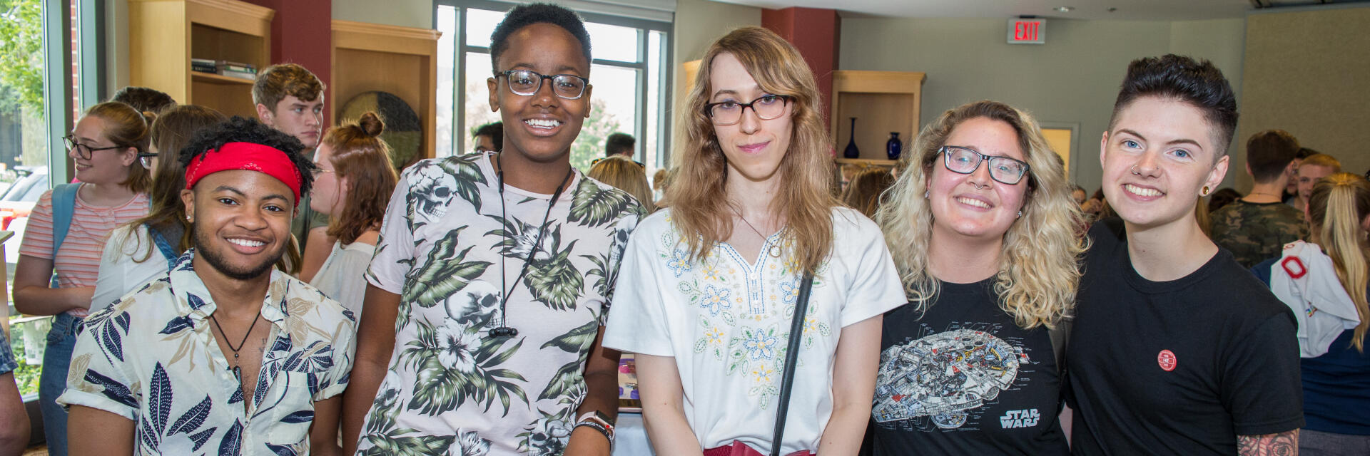 A group of five people standing side-by-side and smiling at the camera.