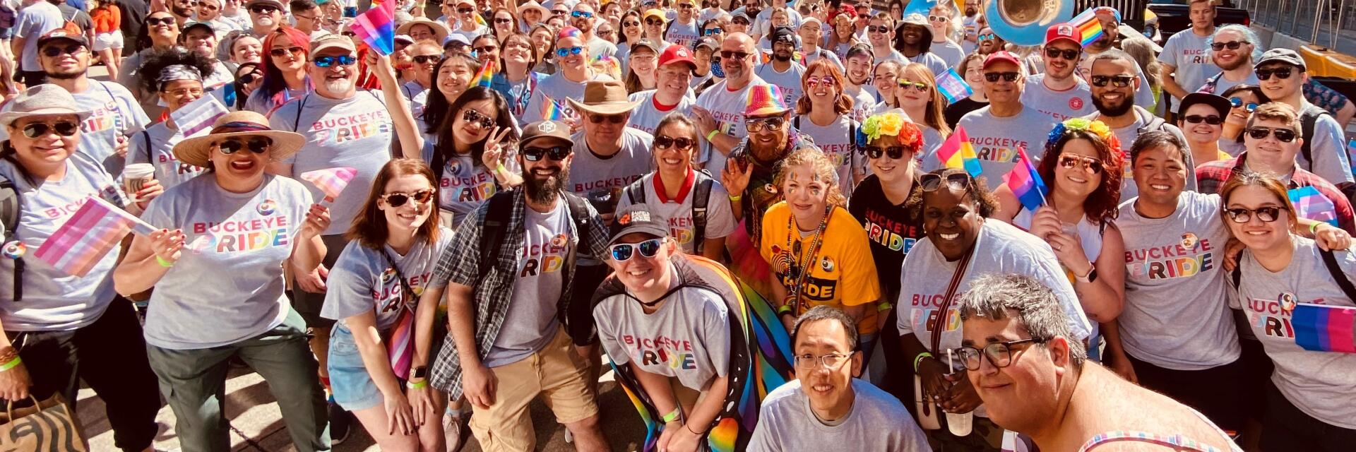 An excited group of people standing together wearing shirts with the text 